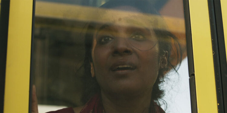 A young woman looks out a window terrified in the movie Yellow Bus.