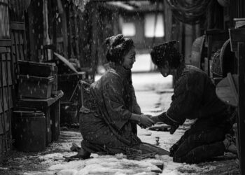 Haru Kuroki as Okiku kneeling on the ground in the street holding a man's hand as snow falls in the movie Okiku and the World.