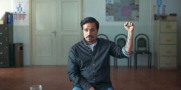 Man holding his fist up in the film Terrestrial Verses.