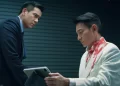 Andy Lau as George Lam holding a tablet sitting across from Eddie Peng as Eddie Fong in I Did It My Way.