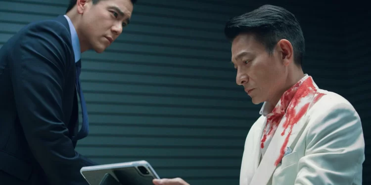 Andy Lau as George Lam holding a tablet sitting across from Eddie Peng as Eddie Fong in I Did It My Way.