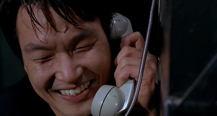 Han Suk-kyu as Mak-dong on the telephone grinning in Lee Chang-dong's movie Green Fish.
