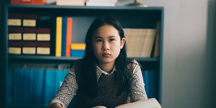 Chloé Djandji as Tinh sitting at a desk studying in the movie Ru