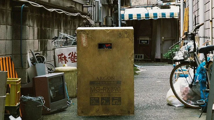 A tall box in a street alley from the movie The Box Man.