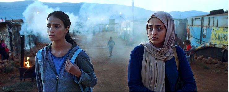 Maria Hassan as Rima and Hala Hosni as Nour walk side by side down a dirt road in the movie Valley of Exile.