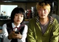 Song Kang-ho as Gang-du and Ko A-sung as Hyun-seo sitting on a couch in the movie Host.
