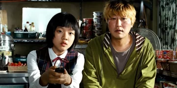 Song Kang-ho as Gang-du and Ko A-sung as Hyun-seo sitting on a couch in the movie Host.