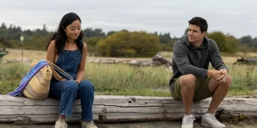 Andrea Bang as Waverly and Robbie Amell as Blake sit together on the beach in Float, directed by Sherren Lee.