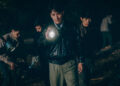Zhu Yilong as Ma Zhe holding a flashlight investigating a scene in the Only the River Flows.