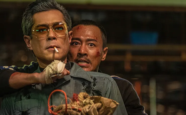 Raymond Lam as Chan Lok-kwan iholding a knife against the throat of Louis Koo as Tornado in Twilight of the Warriors: Walled In.