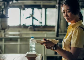 A tear rolls down Zhao Tao's face as she holds a takeout container of rice in Caught by the Tides.