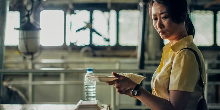 A tear rolls down Zhao Tao's face as she holds a takeout container of rice in Caught by the Tides.