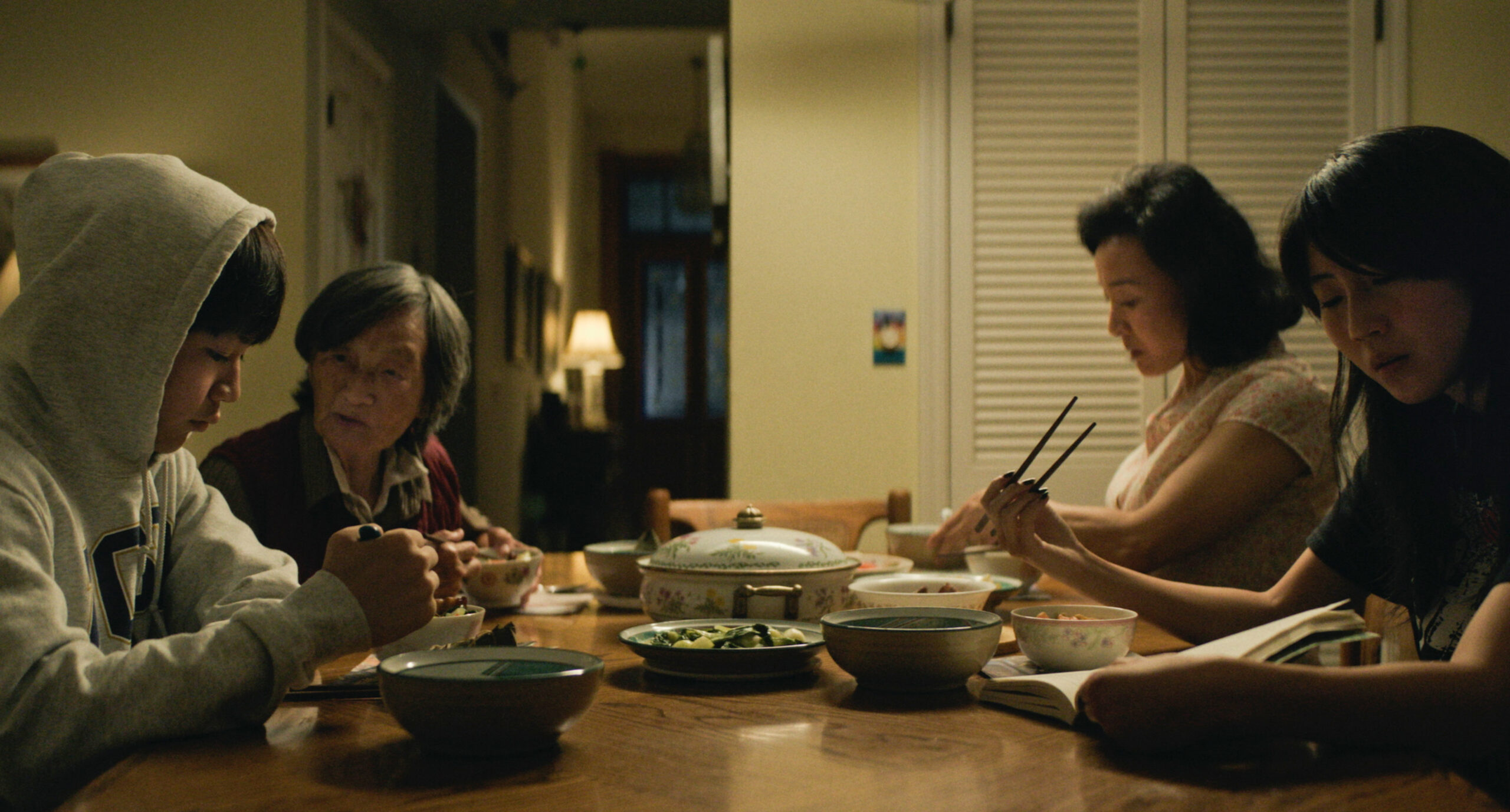 Izaac Wang Chris Wang and his family, Chang Li Hua as Nai Nai, Joan Chen as Chungsing Wang, and Shirley Chen as Vivian Wang, sit at their dinner table in Dìdi (弟弟).