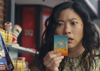 Awkwafina as Katie Kim staring at a lottery ticket in the movie Jackpot.