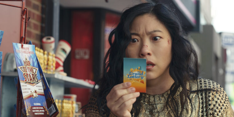 Awkwafina as Katie Kim staring at a lottery ticket in the movie Jackpot.