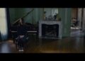 Sitting on a piano bench Mia Wasikowska plays India in Stoker.
