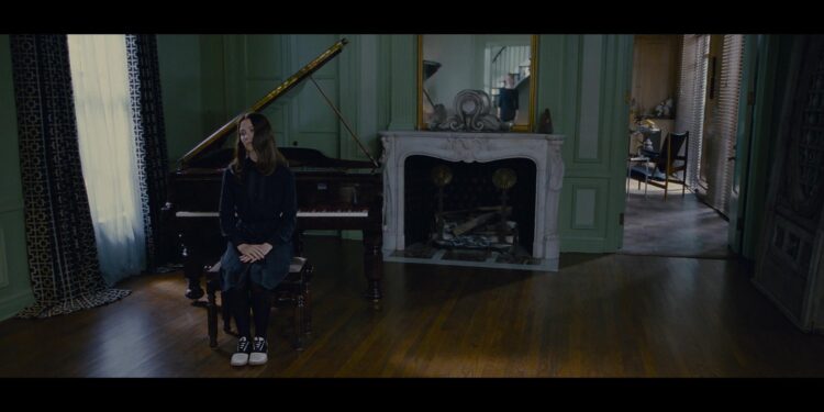 Sitting on a piano bench Mia Wasikowska plays India in Stoker.