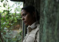 Shahana Goswami as Santosh Saini stands in a doorway looking pensively outside in Santosh
