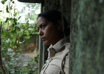 Shahana Goswami as Santosh Saini stands in a doorway looking pensively outside in Santosh