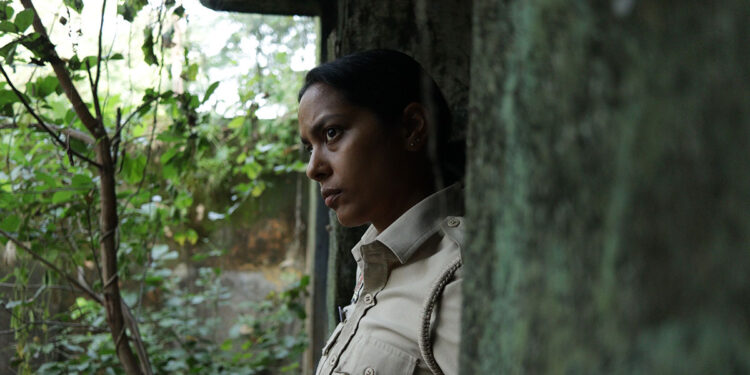 Shahana Goswami as Santosh Saini stands in a doorway looking pensively outside in Santosh