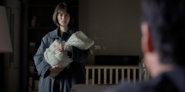 Jung Yu-mi as Soo-ji holds her baby and looks at her husband Hyun-su, played by Lee Sun-kyun