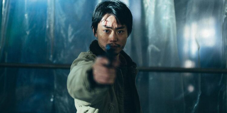 Masaki Suda as Yoshii aiming a gun towards us in the movie Cloud.