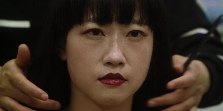 Close up of an Asian woman seated at the hairdresser in Elizabeth Lo's documentary Mistress Dispeller