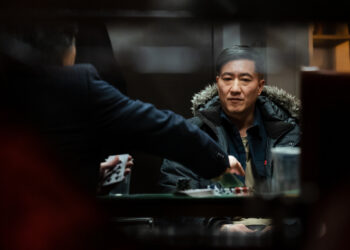 Terry Chen as Lucky sits at a poker table in the movie Lucky Star.