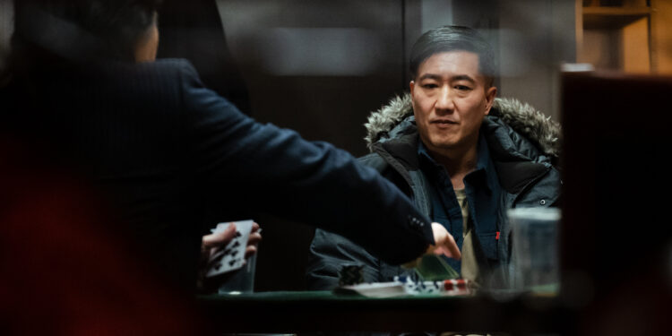 Terry Chen as Lucky sits at a poker table in the movie Lucky Star.