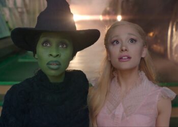 A medium close-up of Cynthia Erivo as Elphaba and Ariana Grande as Galinda in Wicked, as they stare up in awe of Emerald City.