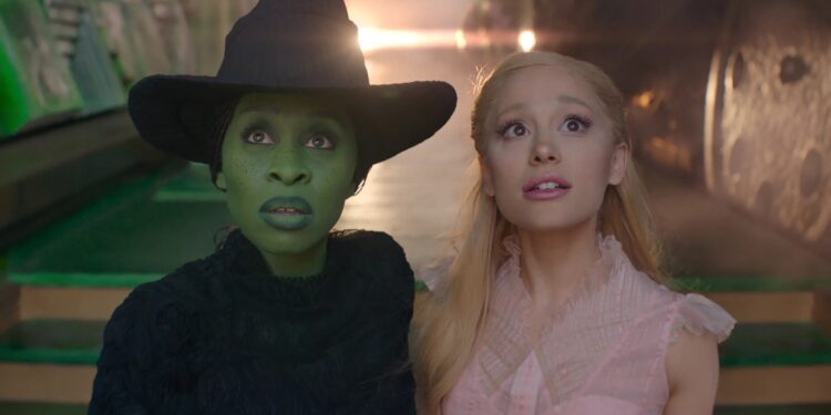 A medium close-up of Cynthia Erivo as Elphaba and Ariana Grande as Galinda in Wicked, as they stare up in awe of Emerald City.