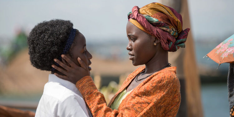Lupita Nyong'o as Nakku Harriet embracing Madina Nalwanga as Phiona Mutesi in Queen of Katwe