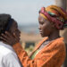 Lupita Nyong'o as Nakku Harriet embracing Madina Nalwanga as Phiona Mutesi in Queen of Katwe