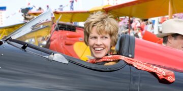 Hilary Swank as Amelia Earhart seated in a black airplane in Amelia