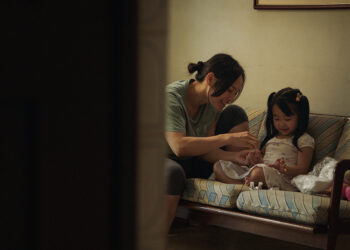 Thi Diu Ta as Hanh and Aster Yeow Ee as Ting Ting sit on a sofa smiling in Oasis of Now.