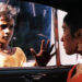 Shafiq Syed as Krishna looking into a car in Salaam Bombay!