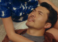 Henry Golding as Nicholas laying in the lap of his partner in Daniela Forever