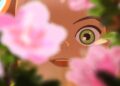 An extreme close-up of Amélie looking through a rose bush in Little Amélie or the Character of Rain.