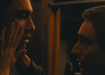 Théodore Pellerin as Matthew holds the face of Archie Madekwe as Oliver in Lurker.