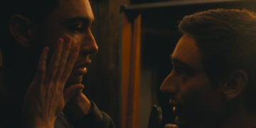 Théodore Pellerin as Matthew holds the face of Archie Madekwe as Oliver in Lurker.