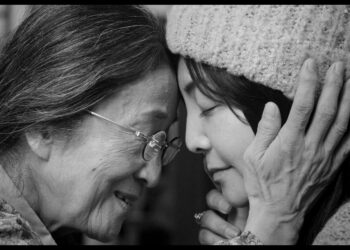 Hana Kino as Grandma and Mayumi Yoshida as Kana gently embracing in Akashi