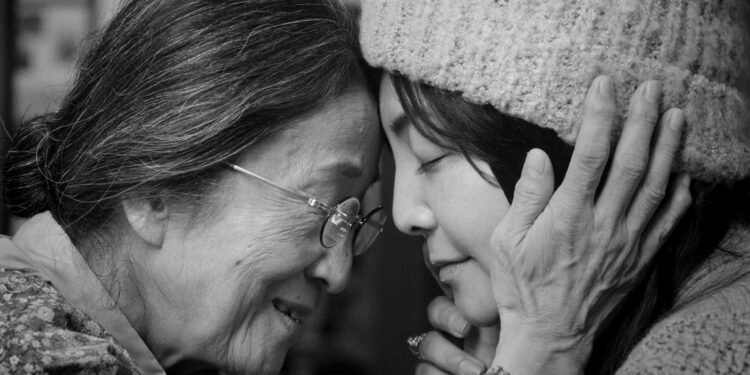 Hana Kino as Grandma and Mayumi Yoshida as Kana gently embracing in Akashi