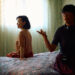 Joan Chen and Xiaodan He sitting on a bed behind the scenes of Montreal ma belle