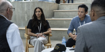 Meaghan Rath as Anushka Bhattachera-Phister and Curtis Lum as Tim Kwan sitting at a table in The Audacity