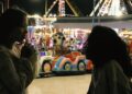 Sopheanith Thong and Deka Nine as Nisay and Thida in Whisperings of the Moon, having an intimate conversation at an amusement park.