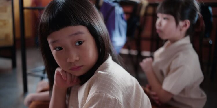 Ong Xuan Jing as Ah Girl sitting in a classroom in Ah Girl.